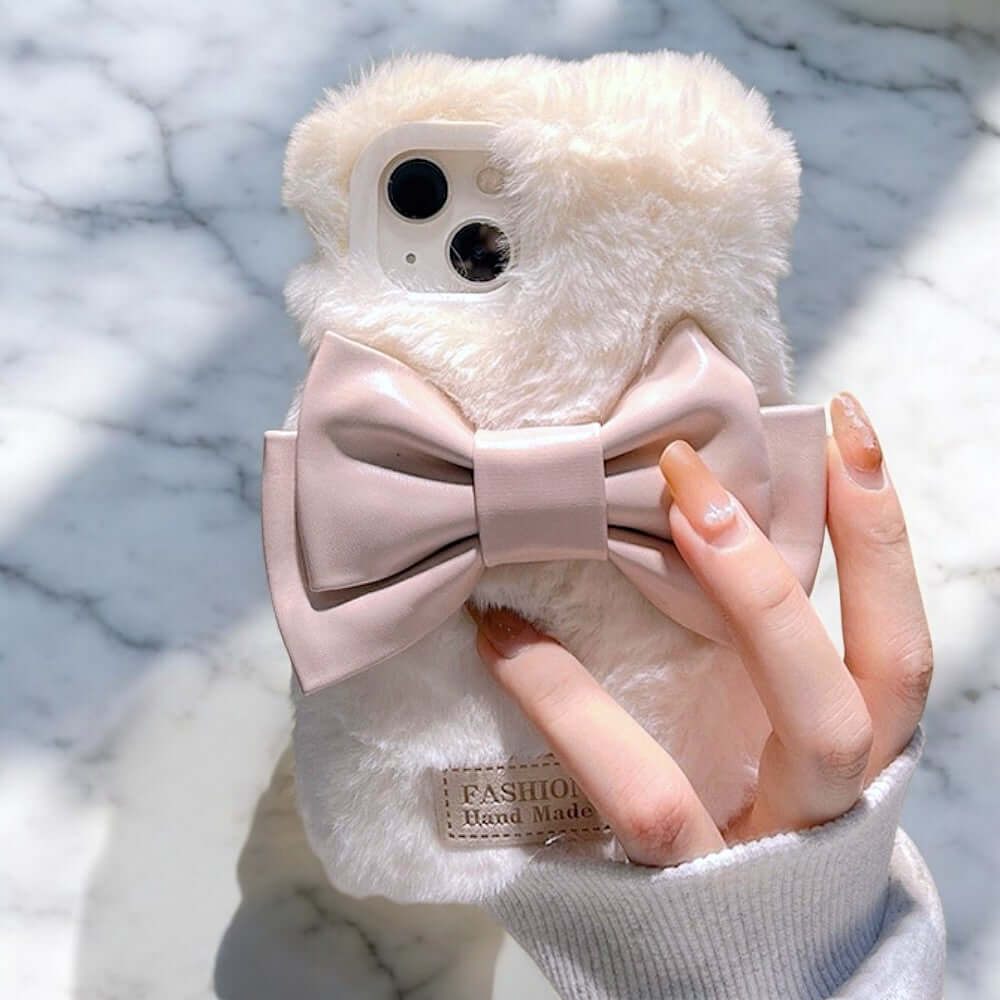 a person holding a white teddy bear with a pink bow tie