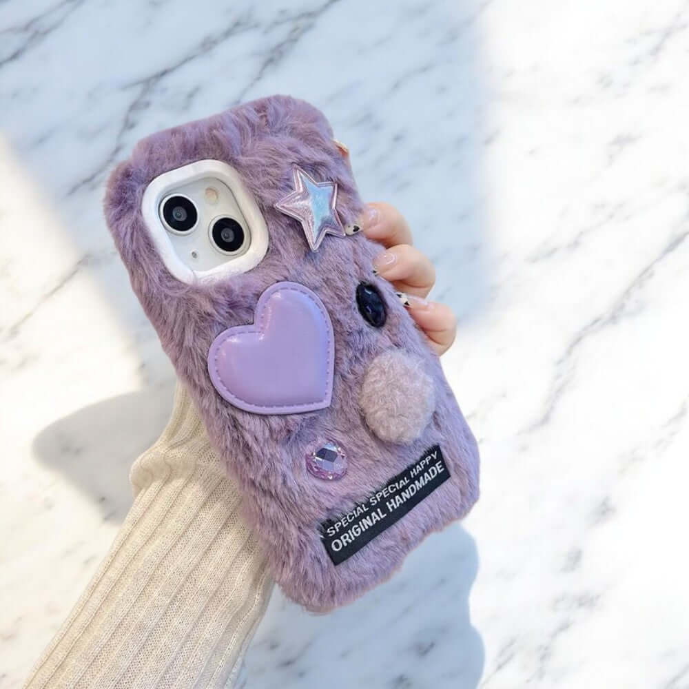 a person holding a purple phone case with a heart on it