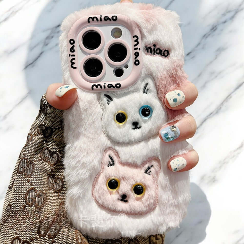 a woman holding a phone case with two cats on it