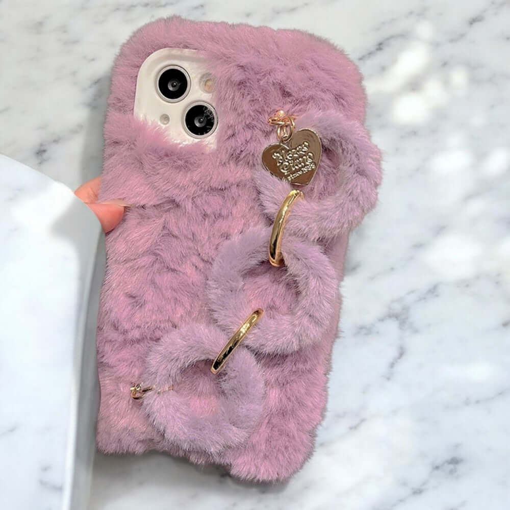 a pink furry phone case with a heart charm