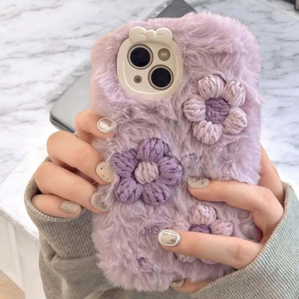 a woman holding a cell phone case with flowers on it