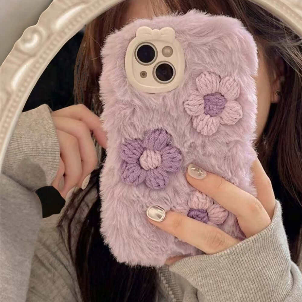 a woman holding a cell phone case with flowers on it