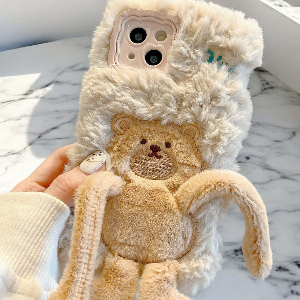 a person holding a teddy bear in their hand