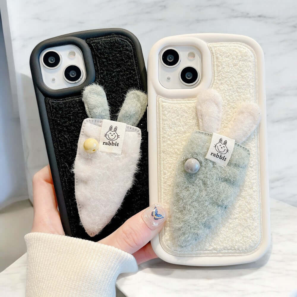 a person holding two iphone cases with bunny ears on them