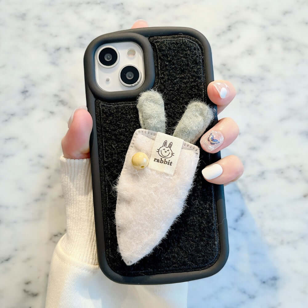 a person holding a phone case with a small animal in it