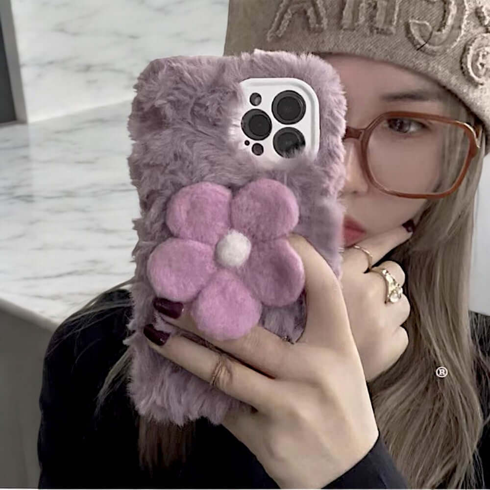 a woman holding a cell phone with a flower on it