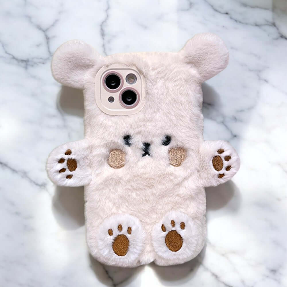 a white teddy bear phone case sitting on a marble surface