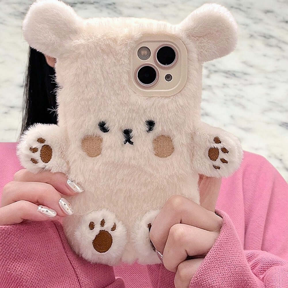 a woman holding a white teddy bear phone case