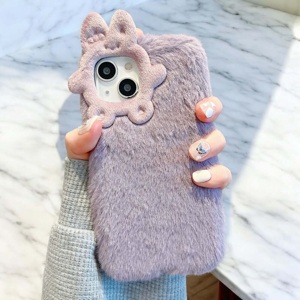 a woman holding up a cell phone case with a cat on it